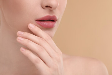 Poster - Young woman with beautiful full lips on beige background, closeup