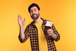 Smiling man with passport and tickets waving hello on yellow background