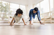 © fizkes - Athletic strong Indian dad and little daughter kid doing pushups, exercising at home, caring for power, strength, wellness, sport. Father training girl, teaching to keep fit, be strong