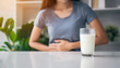 © Your Hand Please - Blurred woman's hand on table with milk, depicting lactose intolerance