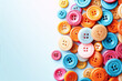 © jamalnasro - A pile of colorful buttons in pink, blue, orange, and yellow scattered on a blue background.