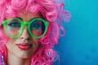 Closeup portrait of a glamourous woman with pink hair and green glasses on blue background