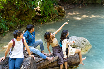 Wall Mural - Group of Young Asian man and woman enjoy and fun outdoor lifestyle travel nature forest on summer holiday vacation. Happy generation z people friends relaxing and playing together at waterfall lagoon.