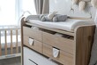 Baby room with cradle and adjacent chest of drawers with changing station