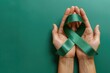 A green ribbon is being held by two hands, symbolizing support for a cause