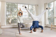© fizkes - Cheerful Indian yogi dad and little daughter kid doing yoga at home, keeping headstand and tree pose, looking at camera, smiling, exercising together, enjoying activity