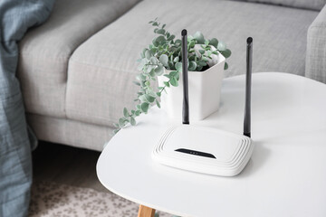 Poster - Modern wi-fi router and plant on table in living room, closeup