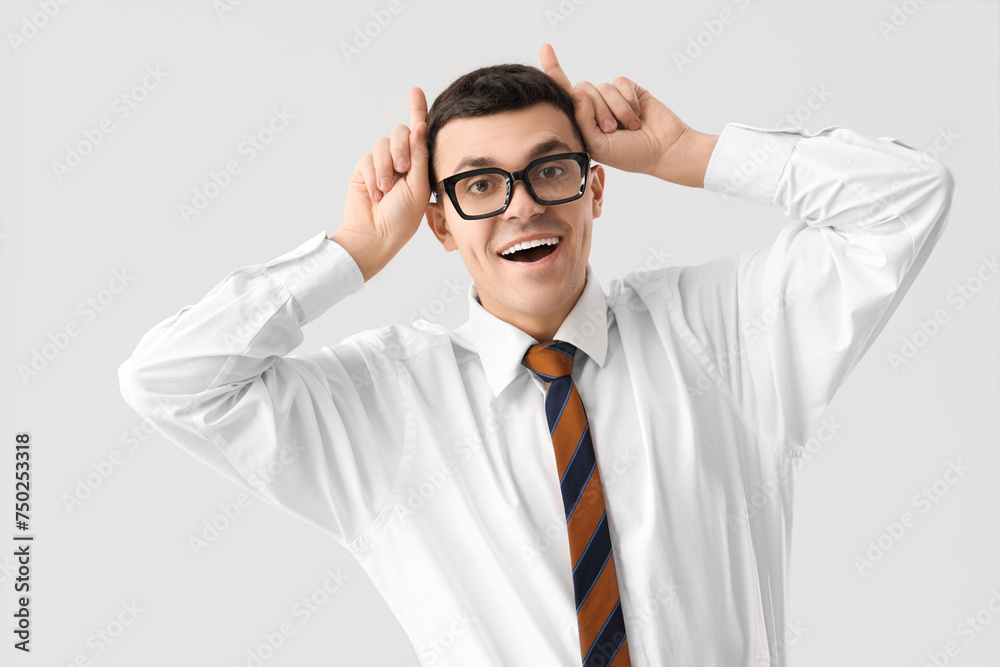 Funny businessman in eyeglasses on light background