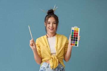 Poster - Female Asian artist with brush and paints on blue background