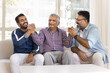 © fizkes - Happy elderly Indian grandpa shaking hands in friendship gesture with mature son and young adult grandson, getting support, enjoying strong family relations, generations bonding