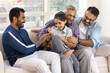 © fizkes - Happy young adult Indian father, grandpa, great granddad playing with sweet little preschool kid girl on sofa, tickling laughing and giggling child, enjoying family playtime, funny leisure