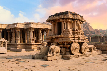 famous ancient stone chariot of hampi in closeup view with other architecture ruins at karnataka, in