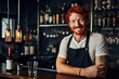 The red-haired male bartender was smiling as he stood at the bar counter with several bottles of alcohol.