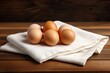 Chicken eggs on a napkin on a wooden table