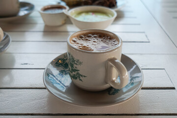 Wall Mural - Popular drink in Malaysia called Teh Tarik. It is a sweet drink made from tea with milk. Fractal on the cup is generic print.