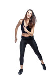 Fototapeta Dziecięca - A slender woman in sportswear does exercises. Beautiful brunette in black leggings and top. Health, sports and slimness. Full height. Isolated on a white background. Vertical.