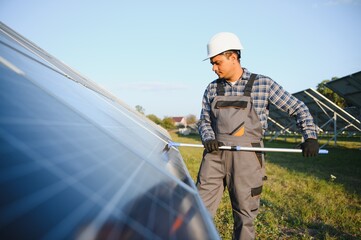 Wall Mural - Indian handyman cleaning solar panels form dust and dirt