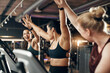 © Flamingo Images - Ecstatic group of fit young women in sportswear laughing and high-fiving together after a cardio workout session on stationary bikes in a health club