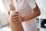 Fototapeta Tematy - Crop osteopath doing manipulations on leg of woman