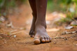 a close up of a black african childs foot as they walk barefoot along a dirt road. Generative ai