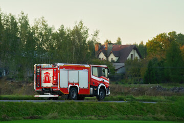 A firetruck rushes to the scene of a fire. The firefighters on board are prepared to save lives and put out the flames. The siren blares as the vehicle speeds through the city streets.