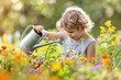 Child boy watering flowers in garden from can 