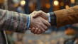 Close-up image capturing a firm handshake between two individuals, denoting a business agreement or friendly introduction, set against a softly blurred background with warm, ambient hues.