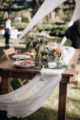 Wall Mural - Many small pink and white flower arrangements with roses, eustoma and various flowers in clear glass vases. On the festive table in the wedding banquet area, compositions of flowers and greenery, cand