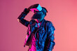 © Jira - VR Exploration: A stylishly dressed man with a beard gazes into the virtual world, his expression a mix of curiosity and wonder. Vivid neon lighting bathes the scene in a futuristic glow