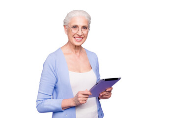 Sticker - Grey haired old smiling business woman wearing glasses, reading browsing using holding tablet. Isolated over violet purple background