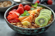 Bowl with baked granola fruits and berries. Healthy breakfast of organic muesli with nuts and sliced exotic fruits. Sweet dessert dieting food concept