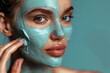 Close up photo of young woman with cosmetic face mask. Portrait of beautiful girl taking care of her facial skin. Cosmetology and spa concept