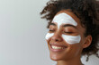 Woman applying facial clay mask. Beautiful girl with cosmetic peel off mask on her face. Beauty and spa treatment. Natural skin care and cleansing concept