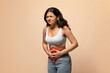 © Prostock-studio - Sick indian woman having stomach ache, touching abdomen with red inflamed zone