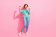 Full length photo of glad overjoyed person raise fist use smart phone empty space isolated on pink color background