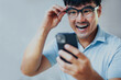 © panitan - adult asian man using mobile, cell phone.young male person.posing smiling laughing look excited surprised thinking positive happy.empty,copy space for text advertising.grey background