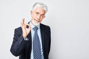 Wall Mural - Senior businessman making OK gesture with hand isolated on white background.