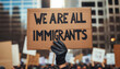 © ADDICTIVE STOCK - A bold message on a cardboard sign reads 'We Are All Immigrants' at a peaceful rally. Generative AI
