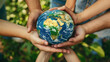 A group of people holding a globe together in a show of unity and care, suitable for illustrating concepts of global cooperation or Earth Day celebrations