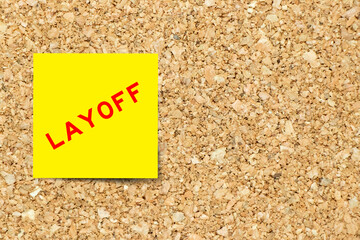 Sticker - Yellow note paper with word layoff on cork board background with copy space