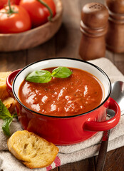 Wall Mural - Bowl of tomato soup garnished with basil leaves