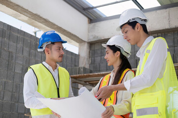 Wall Mural - Civil engineer teams meeting working together wear worker helmets hardhat on construction site in modern city. Foreman industry project manager engineer teamwork. Asian industry professional team