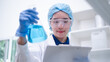 © Supapich - Woman scientist chemist holding laboratory blue liquid beaker test tube equipment for discovery analysis science chemical medicine development experiment technology biotechnology development