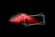 Freeze motion of red color powder exploding on black background.