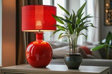 Close-up View Of Red Table Lamp On A Table And Lucky Bamboo (Dracaena Sanderiana) In A Ceramic Vase. Interior Details Of Modern Room. Combination Of Classic And Oriental Ambience.