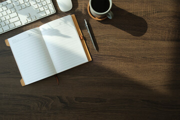 Wall Mural - Flat lay notebook, coffee cup and potted plant on wood office desk.