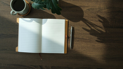 Wall Mural - Flat lay notebook, coffee cup and potted plant on wood office desk.