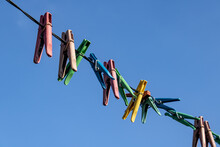 Clothes Pins Hanging On Blue Sky And Rope