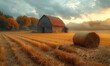 Barn and hay bale in field at sunset