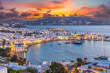 Fototapeta Góry - Embrace the warm hues of sunset in Mykonos Town Chora, where the Aegean Sea's azure waters reflect the vibrant life of this iconic Greek island.